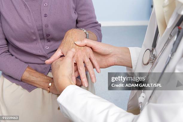 rheumatoid arthritis, general practitioner examining patient and hand for signs of rheumatoid arthri - artrite reumatoide - fotografias e filmes do acervo