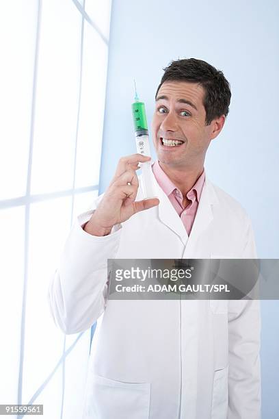 doctor holding syringe - surgeon holding needle stock-fotos und bilder