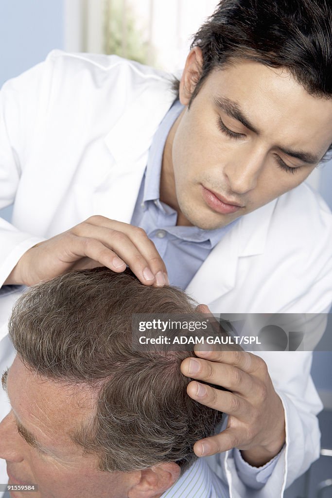 Trichologist examining scalp of patient
