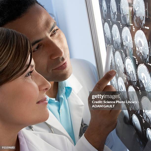 doctors examining mri scans - sutura stock-fotos und bilder