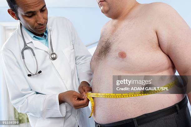 general practitioner measuring waist of obese patient - general practitioner imagens e fotografias de stock