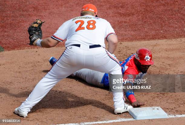 Anthony Garcia Criollos de Caguas of Puerto Rico is tagged out at first base by Balbino Fuenmayor , Caribes de Anzoategui of Venezuela, during...