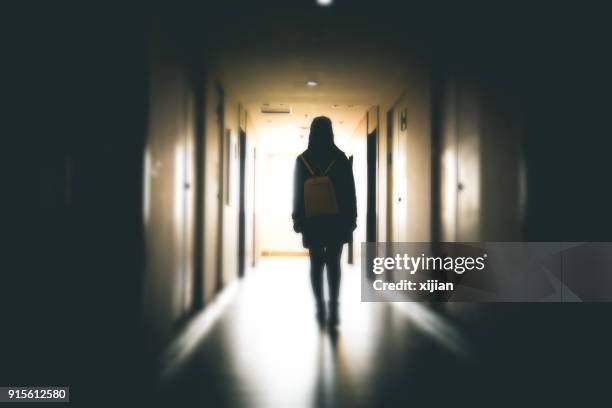 giovane donna in passerella edificio buio - aggressione foto e immagini stock