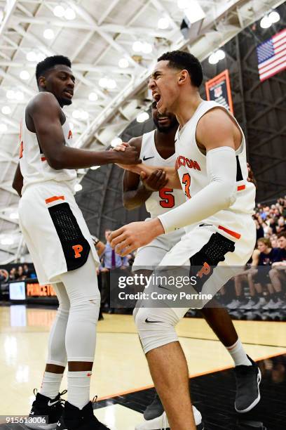 Devin Cannady reacts to being fouled as he is helped up by teammates Myles Stephens and Amir Bell of the Princeton Tigers during the first half...