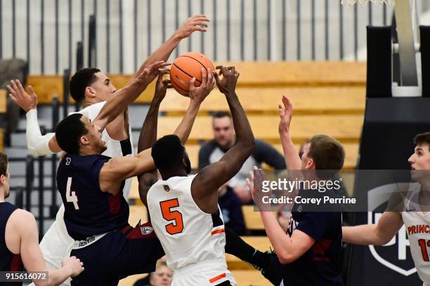 Darnell Foreman of the Pennsylvania Quakers drives to the basket as Devin Cannady and Amir Bell of the Princeton Tigers defend during the second half...