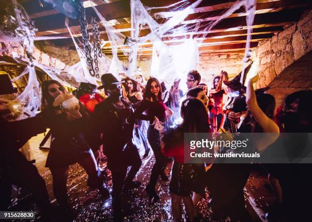 multi-ethnic people in halloween costumes having fun at dungeon nightclub - halloween stock pictures, royalty-free photos & images