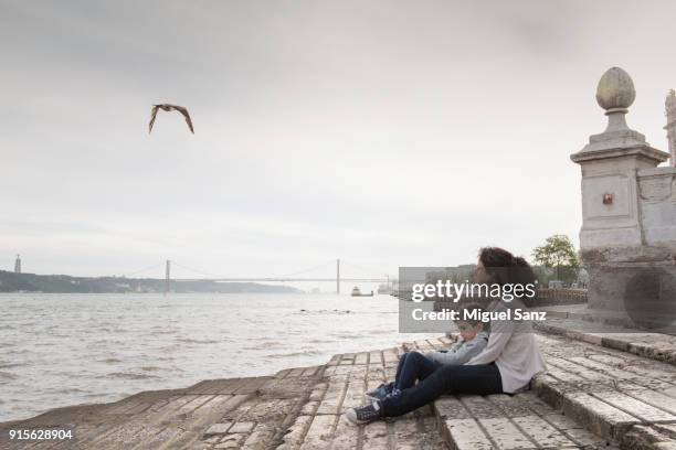 mother and son sitting in cais das colunas, lisbon, portugal - portuguese culture fotografías e imágenes de stock