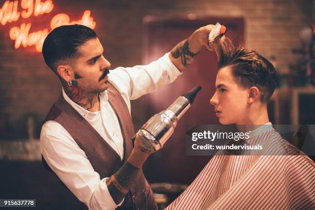 young stylish hairdresser blow drying hipster man's hair - retro hair salon stock pictures, royalty-free photos & images