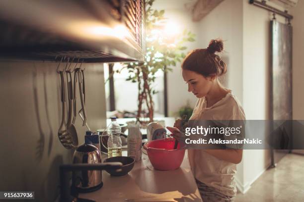 jonge vrouw in de keuken, recept lezen vanaf het internet - baking reading recipe stockfoto's en -beelden