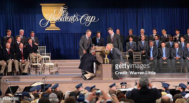 American Captain Fred Couples shakes hands with Greg Norman of the International Team over looked Former President George W. W. Bush and Gavin...