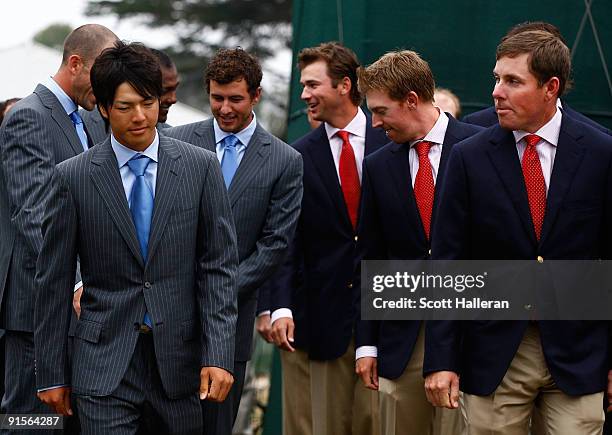 Ryo Ishikawa of the International Team walks to the stage alongside Justin Leonard of the USA Team during the Opening Cermonies prior to the start of...