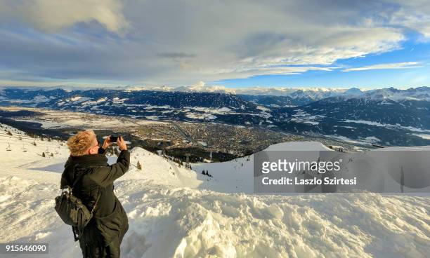 Tourist takes a photo of the city and the Alps at Mount Seegrube on January 26, 2018 in Innsbruck, Austria.