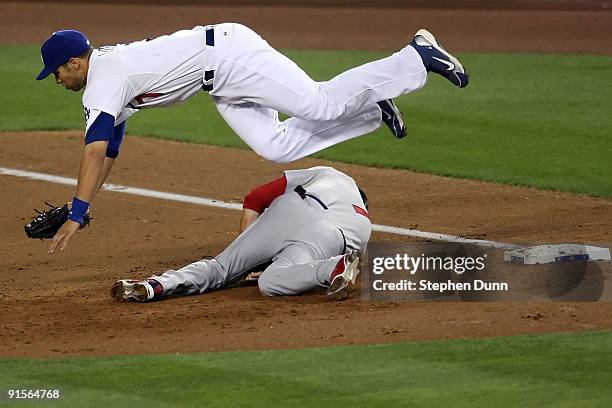 First baseman James Loney of the Los Angeles Dodgers dives over Mark DeRosa of the St. Louis Cardinals to catch the ball in the second inning in Game...