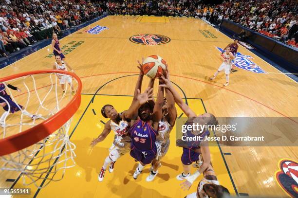 Tamika Catchings of the Indiana Fever rebounds against Le'coe Willingham and Nicole Ohlde of the Phoenix Mercury during Game Four of the WNBA Finals...