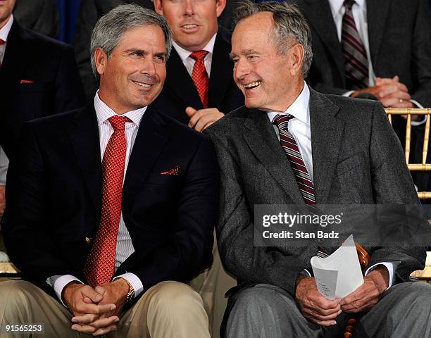 United States team captain Fred Couples, left, and former President George H.W. Bush, right, share a moment on stage during the opening ceremonies...