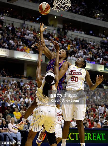 Cappie Pondexter of the the Phoenix Mercury shoots the ball whhile defended by Jessica Moore and Jessica Davenport of the Indiana Fever during the...