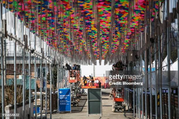 Workers labor under balloon decorations ahead of the 2018 PyeongChang Winter Olympic Games in the Hoenggye-ri village area of Pyeongchang, Gangwon...