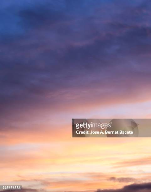 full frame of the low angle view of clouds of colors in sky during sunset. valencian community, spain - cirrus stockfoto's en -beelden