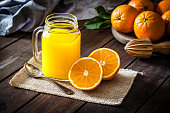 Orange juice glass jar shot on rustic wooden table