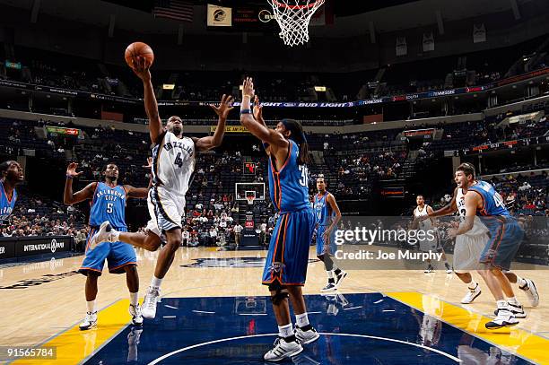 Sam Young of the Memphis Grizzlies drives to the basket for a layup between against DJ White and Etan Thomas of the Oklahoma City Thunder on October...