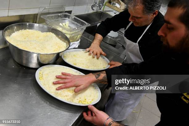 Chefs Matteo Nozzetti and Davide Mora prepare the fettuccine at the Il Vero Alfredo Restaurant in Rome on February 7, 2018 as it celebrates 110 years...