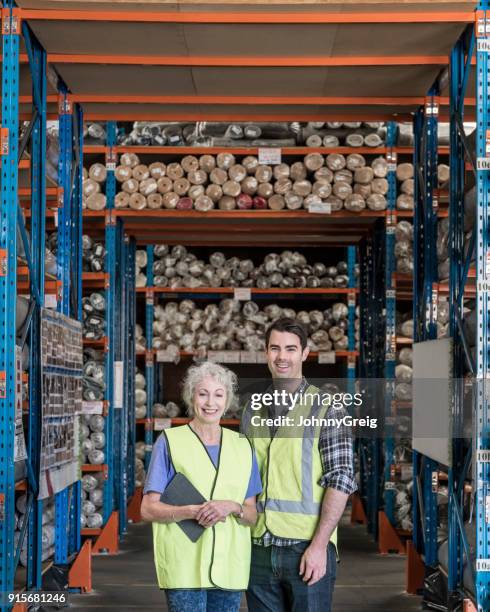 mature woman and mid adult man in carpet warehouse - workplace relations stock pictures, royalty-free photos & images