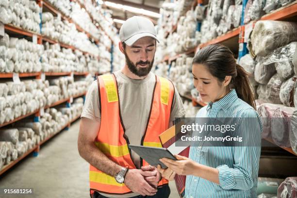 female manager showing male employee tablet in carpet warehouse - stocktake stock pictures, royalty-free photos & images