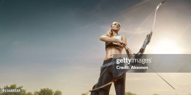 female archer shooting with the longbow at sunset - archery range stock pictures, royalty-free photos & images