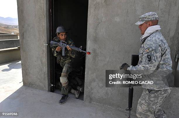 In this photo taken September 27 shows a US Army trainer guides an Afghan soldier during combat training at The Afghan National Army training camp on...