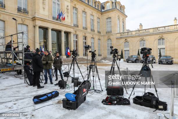 Television reporters and photojournalists wait in the frozen courtyard of the Elysee palace, for the French ministers to leave after the weekly...