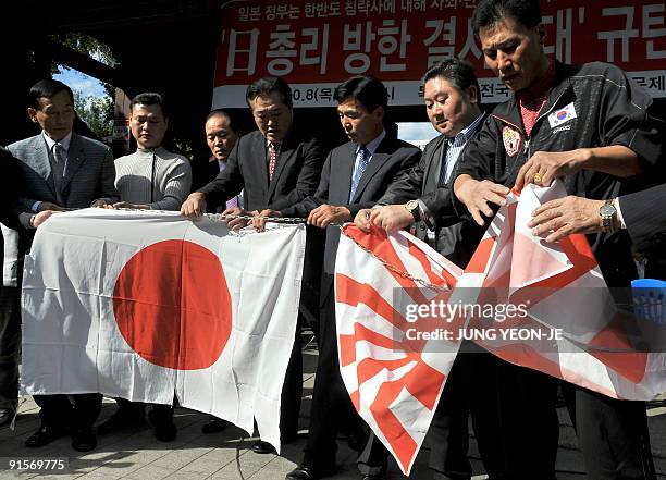 South Korean protestors tear down Japanese flags during an anti-Japanese rally at a downtown park in Seoul on October 8, 2009. The protestors...