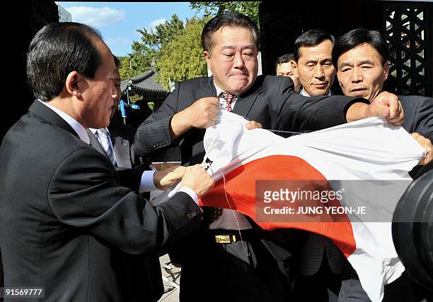 South Korean protestors tear down Japanese flags during an anti-Japanese rally at a downtown park in Seoul on October 8, 2009. The protestors...
