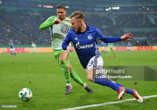 Jeffrey Bruma of Wolfsburg is challenged by Cedric Teuchert of Schalke during the DFB Pokal quarter final match between FC Schalke 04 and VfL...