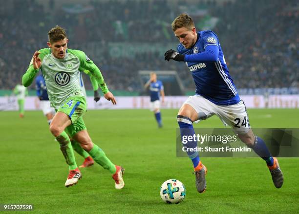 Sebastian Jung of Wolfsburg is challenged by Bastian Oczipka of Schalke during the DFB Pokal quarter final match between FC Schalke 04 and VfL...