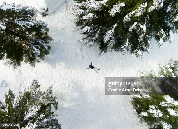 guy taking a original selfie laying on the fresh snow with picture taken from drone directly from above with nice winter landscape. - snow directly above stock pictures, royalty-free photos & images