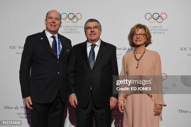 President of the International Olympic Committee Thomas Bach and his wife Claudia Bach stand with Prince Albert of Monaco on the red carpet as they...