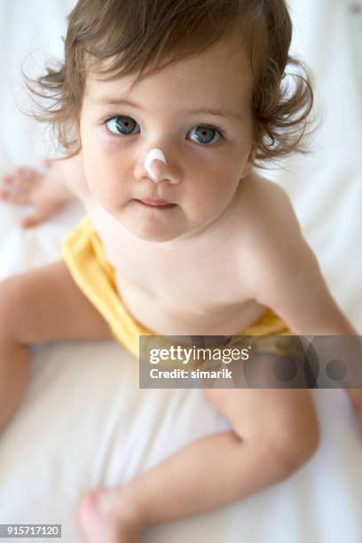 sun protection - baby suncream stock pictures, royalty-free photos & images