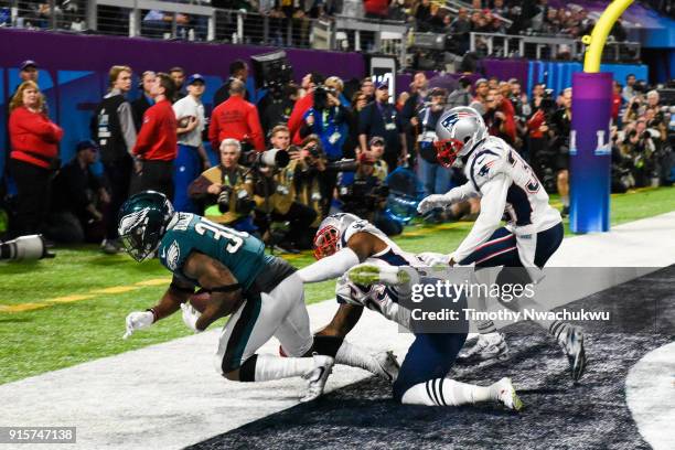 Corey Clement of the Philadelphia Eagles catches a 22-yard touchdown pass past Marquis Flowers and Patrick Chung of the New England Patriots during...
