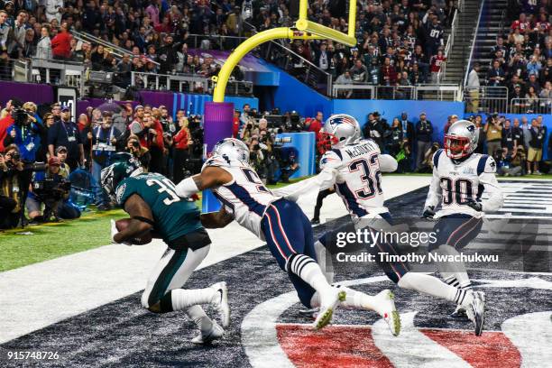 Corey Clement of the Philadelphia Eagles catches a 22-yard touchdown pass past Marquis Flowers, Patrick Chung and Duron Harmon of the New England...