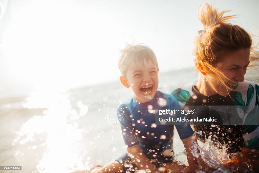 Moeder en zoon genieten van zeewater
