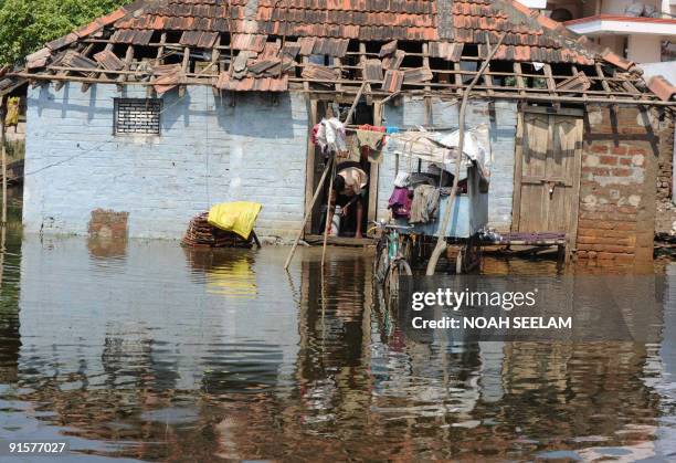 Indian flood victims attempt to dry out their belongings outside their homes at Ibrahimpatnam on the outskirts of Vijayawada, some 300 kms south-east...