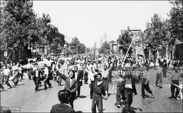 Des manifestants monarchistes qui viennent d'incendier un journal gouvernemental, défilent sur l'Avenue Chah Abbas en plein centre de Téhéran le 26...