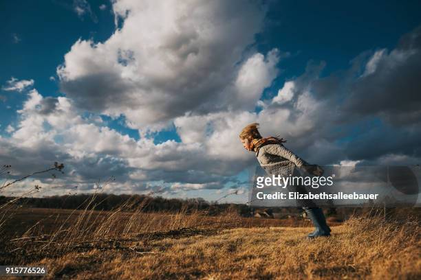 boy standing in rural landscape with his arms outstretched - leaning stock pictures, royalty-free photos & images