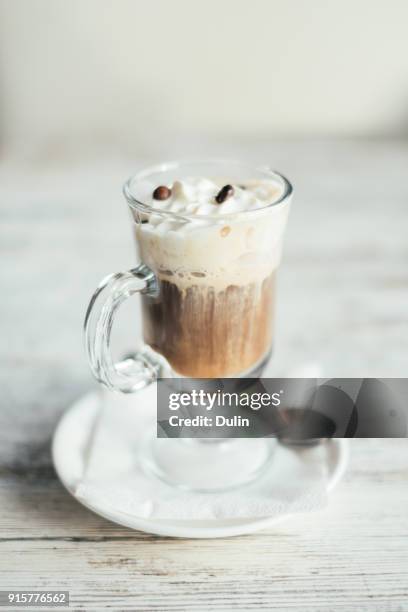 close-up of an irish coffee on a wooden table - irish coffee stock-fotos und bilder