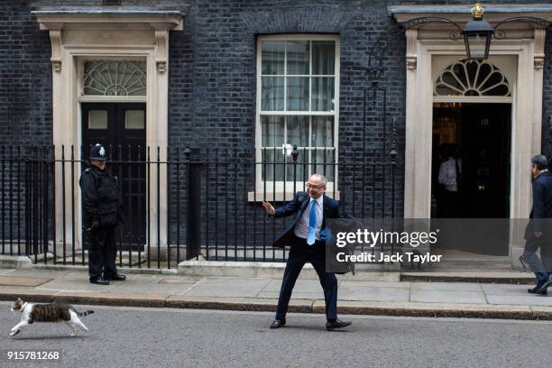 Kazuo Okamoto, chief executive of Mitsubishi Heavy Industries Europe attempts to stroke Larry the Downing Street cat ahead of a meeting with British...