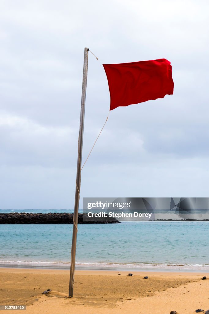 A red flag flying on the beach on the Canary Island of Fuerteventura