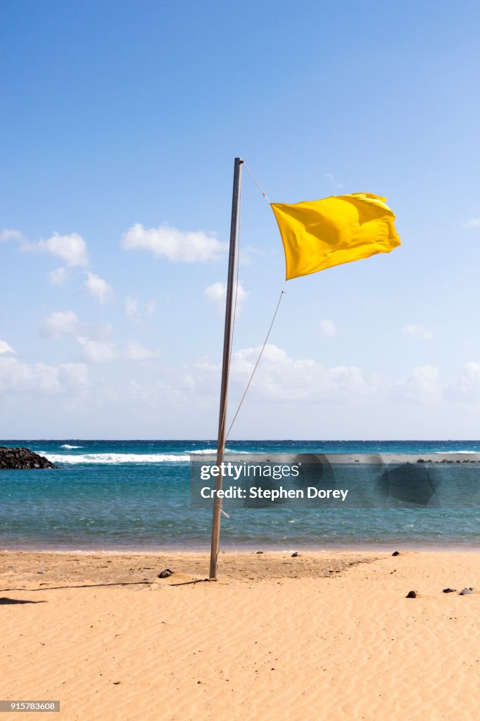 A yellow flag flying on the beach on the Canary Island of Fuerteventura