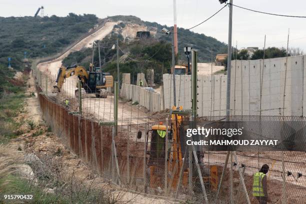 Picture taken on February 8 from Lebanon's southern border town of Naqura, shows an Israeli excavator digging during construction of a dividing wall...