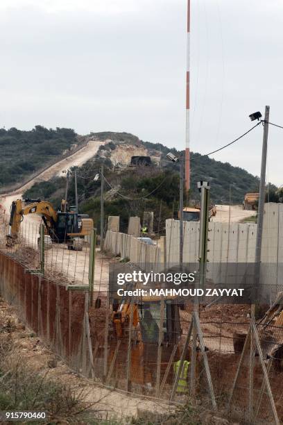 Picture taken on February 8 from Lebanon's southern border town of Naqura, shows an Israeli excavator digging during construction of a dividing wall...