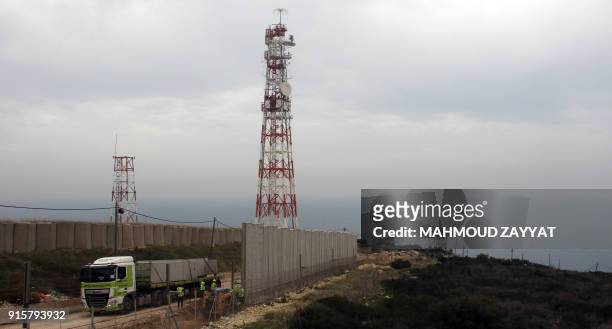Picture taken on February 8 from Lebanon's southern border town of Naqura, shows an Israeli lorry transporting blocs of cement to build sections of a...